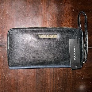 Women’s black Tahari wallet multi pockets and middle zipper for extra storage.